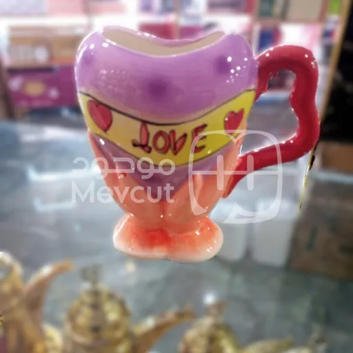 كوب خزفي بشكل قلب ومقبض أحمر مع قاعدة على شكل يدين